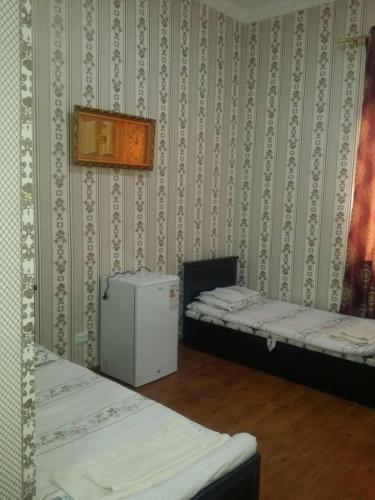 um quarto com duas camas e um pequeno frigorífico em Отель RATMINA- MUINAK em Mŭynoq