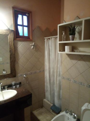 a bathroom with a sink and a shower curtain at Nuestro Lugar in Villa Gesell