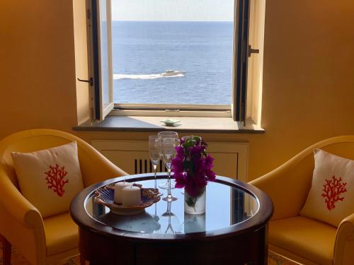 a table with flowers and candles in front of a window at Villa Le Baste in Furore