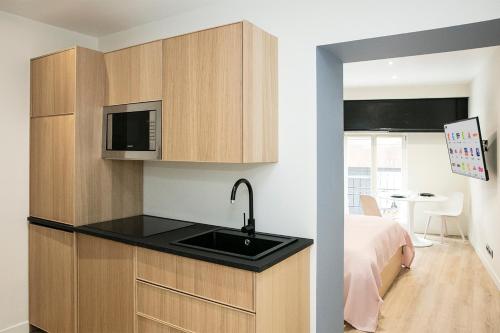a kitchen with a sink and a bed in a room at Apart 1 opera · Modern studio fully furnished in Paris