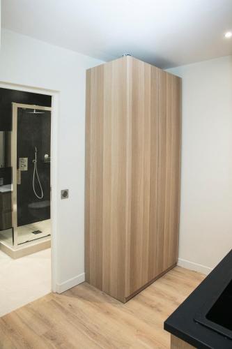 a large wooden cabinet in the corner of a room at Apart 1 opera · Modern studio fully furnished in Paris