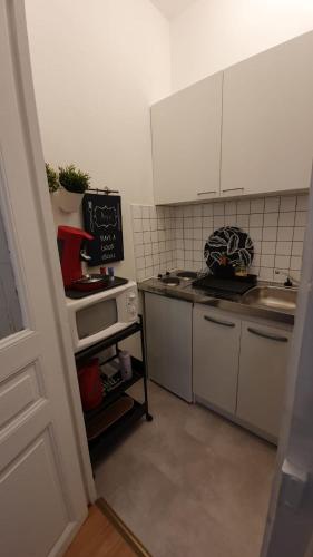 a small kitchen with a sink and a stove at Le Galope, Appartement centre Compiègne in Compiègne