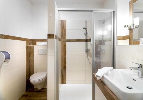 ein Bad mit einem WC, einem Waschbecken und einer Dusche in der Unterkunft SCOL Sporthotel Großglockner in Kals am Großglockner
