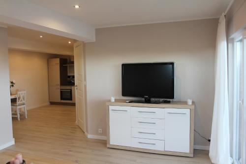 a living room with a flat screen tv on a dresser at Augustenhof Ferien in Nordborg