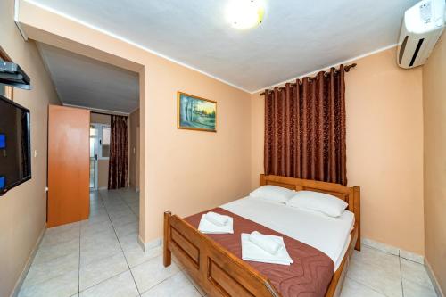 a small bedroom with a bed and a television at Villa Glavanovic in Bar