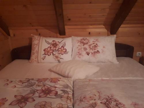a bed with white sheets and pillows in a room at Lodge House Tara in Kolašin