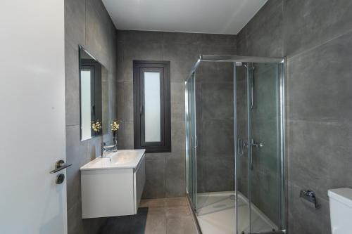 a bathroom with a glass shower and a sink at Villa Andre, walking distance to Coral Bay in Peyia