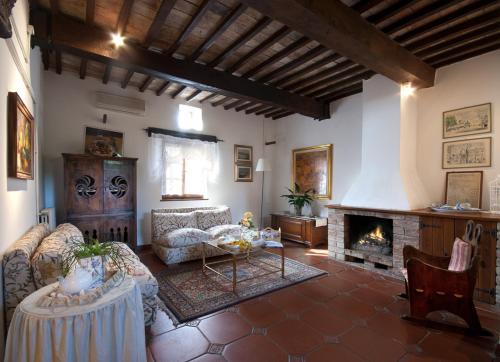 salon z kanapą i kominkiem w obiekcie Agriturismo Renello w mieście Petroio