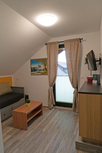 a living room with a couch and a window at Apartments Helena Kranjska Gora in Kranjska Gora