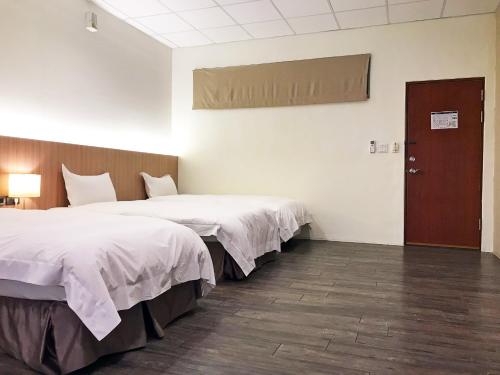 Postel nebo postele na pokoji v ubytování NCNU Campus Inn暨大行旅