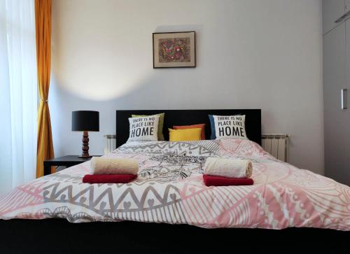 un letto con coperta e cuscini rosa e bianchi di City Center Lovely Studio Apartment a Belgrado