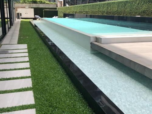 a swimming pool with grass on the side of it at Lumiere Puerto Madero in Buenos Aires