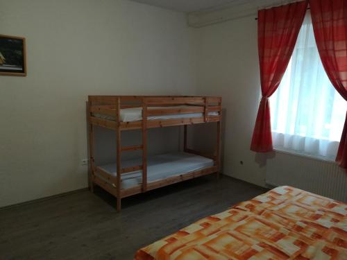1 dormitorio con litera en una habitación con 2 ventanas en Sümegi Levendula Apartmanok, en Sümeg
