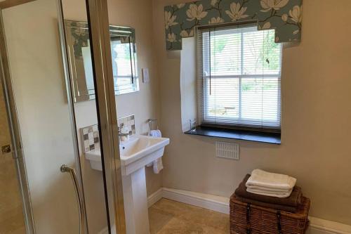 a bathroom with a sink and a shower at Sygun Cottage - Detached Cottage in the heart of the Snowdonia National Park in Beddgelert