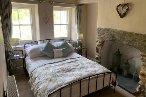 a bedroom with a large bed and a fireplace at Sygun Cottage - Detached Cottage in the heart of the Snowdonia National Park in Beddgelert