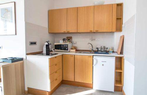 a kitchen with wooden cabinets and a white dishwasher at Agricola Domus in Barolo