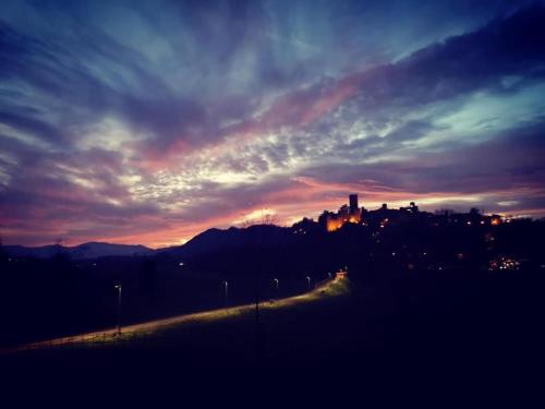 a sunset with a city in the background at Dimora del Podestà in CastellʼArquato