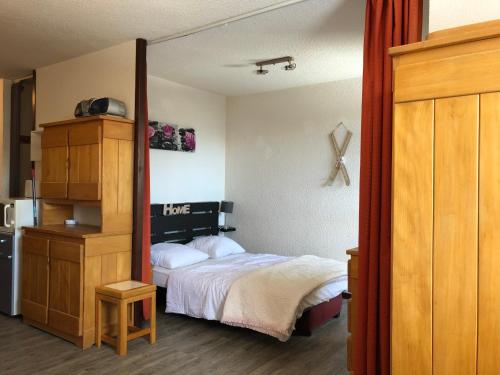 サモエンヌにあるLes Cimesのベッドルーム1室(ベッド1台付)、木製キャビネットが備わります。