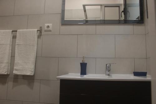 a bathroom with a sink and a mirror and towels at FX Carvalhal in Funchal