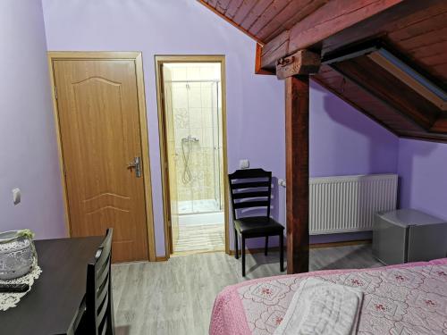a bedroom with a bed and a table and a chair at Casa Suzy & Roxy in Arpaşu de Jos