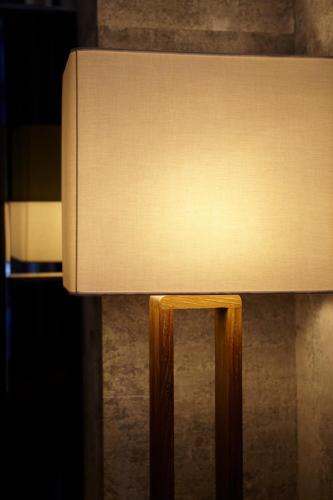a close up of a lamp with a wooden leg at Best Louis Hamilton Hotel Haeundae in Busan
