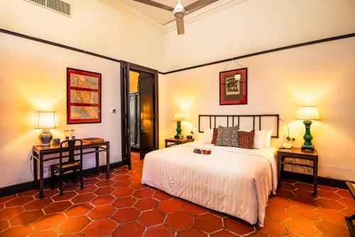 a bedroom with a bed and two tables and two lamps at Cheong Fatt Tze - The Blue Mansion in George Town