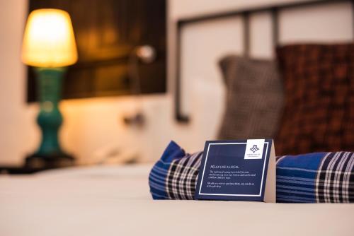 a bed with blue pillows with a sign on it at Cheong Fatt Tze - The Blue Mansion in George Town
