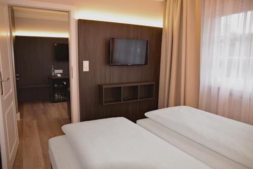 a hotel room with a bed and a television at Fisher's Inn in Zingst