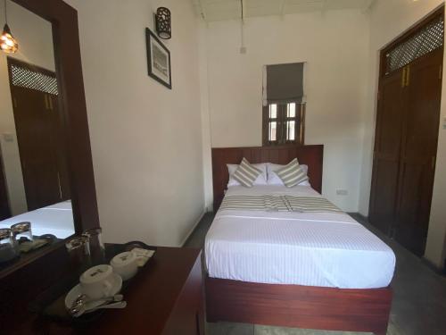 a bedroom with a bed and a desk and a bed sidx sidx sidx at Arches Fort in Galle