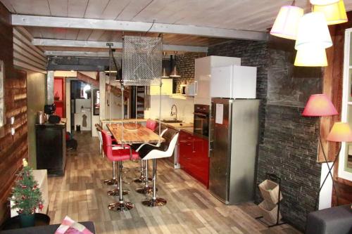 une cuisine avec une table et un réfrigérateur dans l'établissement Appartement atypique au coeur de Gap, à Gap