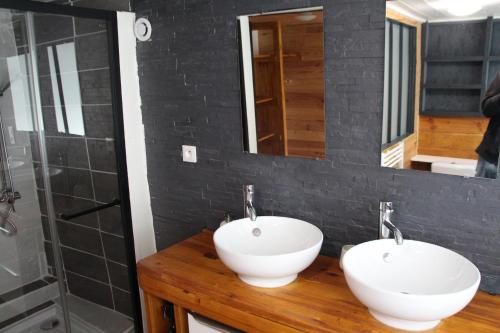 a bathroom with two white sinks and a shower at Appartement atypique au coeur de Gap in Gap