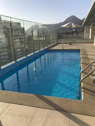 a swimming pool on the roof of a building at Clínica Las Condes, espectacular departamento nuevo 80 m2 in Santiago