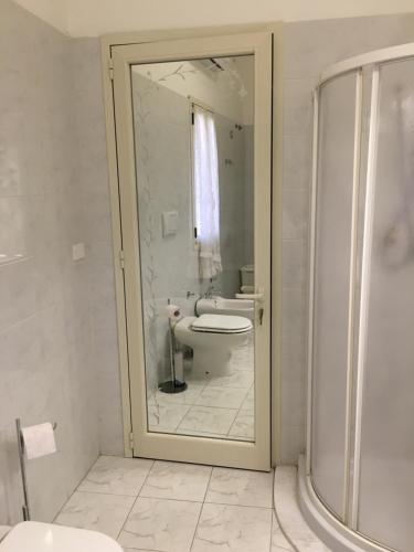 a white bathroom with a toilet and a shower at Casa jole in Assemini