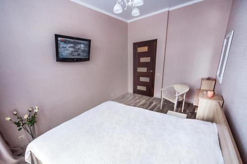 una camera con letto bianco e TV a parete di Однокомнатная VIP квартира на Славянке с террасой a Vinnycja