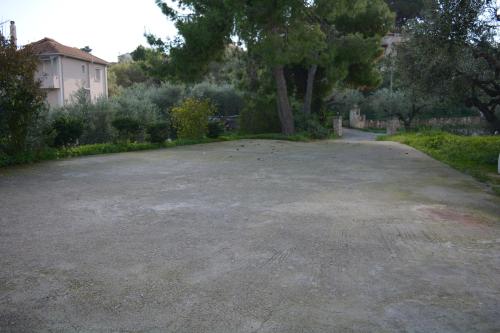 an empty parking lot with a tree and a house at FIORE ROOMS in Akrotiri