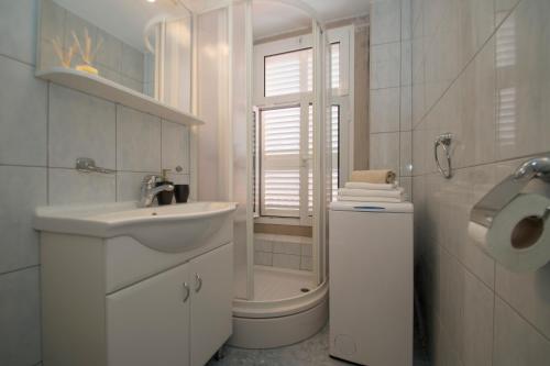 MILINA KORČULA في كورتْشولا: حمام أبيض مع حوض ومرحاض