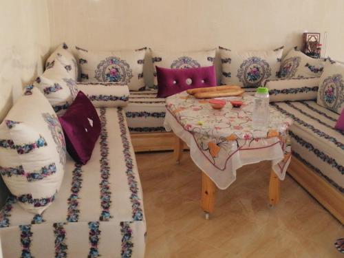ein Wohnzimmer mit Sofas und einem Tisch mit Kissen in der Unterkunft Best Room in Fès