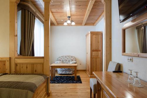 a bedroom with a bed and a table and a chair at Ganz SKI Lift 5 in Bukovel