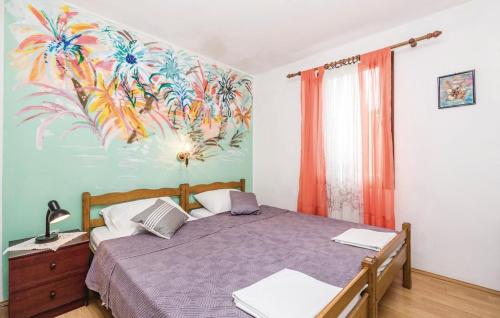 a bedroom with a bed with a painting on the wall at Apartmani Jadra in Stara Novalja