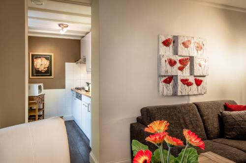 a living room with a couch and red flowers at Aparthotel Ons Epen in Epen