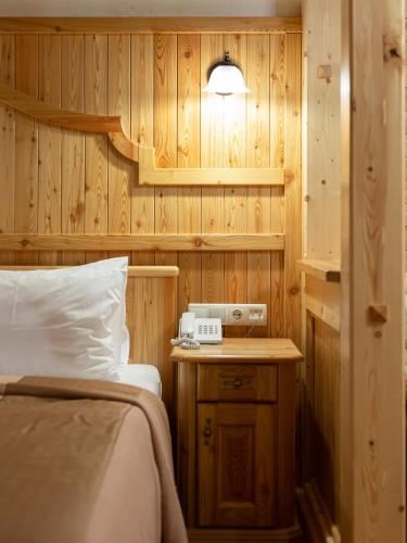 a bedroom with a bed and a wooden wall at Ganz SKI Lift 5 in Bukovel