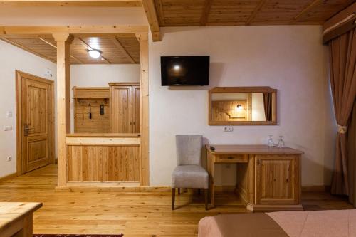 a room with a desk and a television on the wall at Ganz SKI Lift 5 in Bukovel