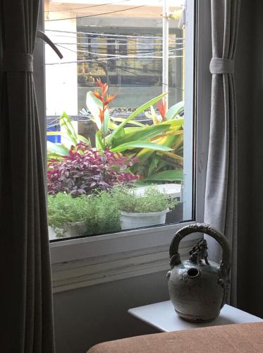 a vase sitting on a table in front of a window at Hanoi Secret Garden in Hanoi
