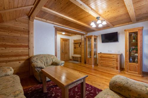 a living room with a table and a tv at Ganz SKI Lift 5 in Bukovel