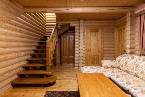 a living room with a spiral staircase in a log cabin at Ganz SKI Lift 5 in Bukovel