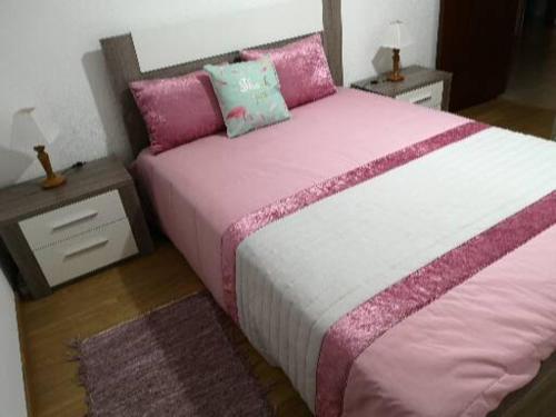 a bedroom with a large bed with pink and white sheets at Vidal house in Santo André