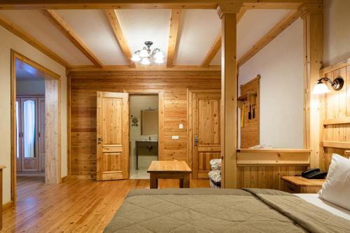 a bedroom with wooden walls and a bed and a table at Ganz SKI Lift 5 in Bukovel
