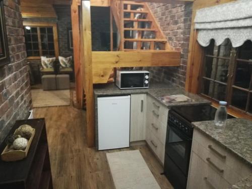 a kitchen with a refrigerator and a microwave at Clarens Cottages in Clarens
