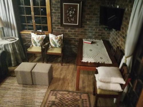 a living room with two chairs and a table at Clarens Cottages in Clarens