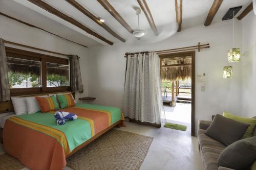 a bedroom with a bed and a couch at La Casa del Alux - Adults Only in Holbox Island